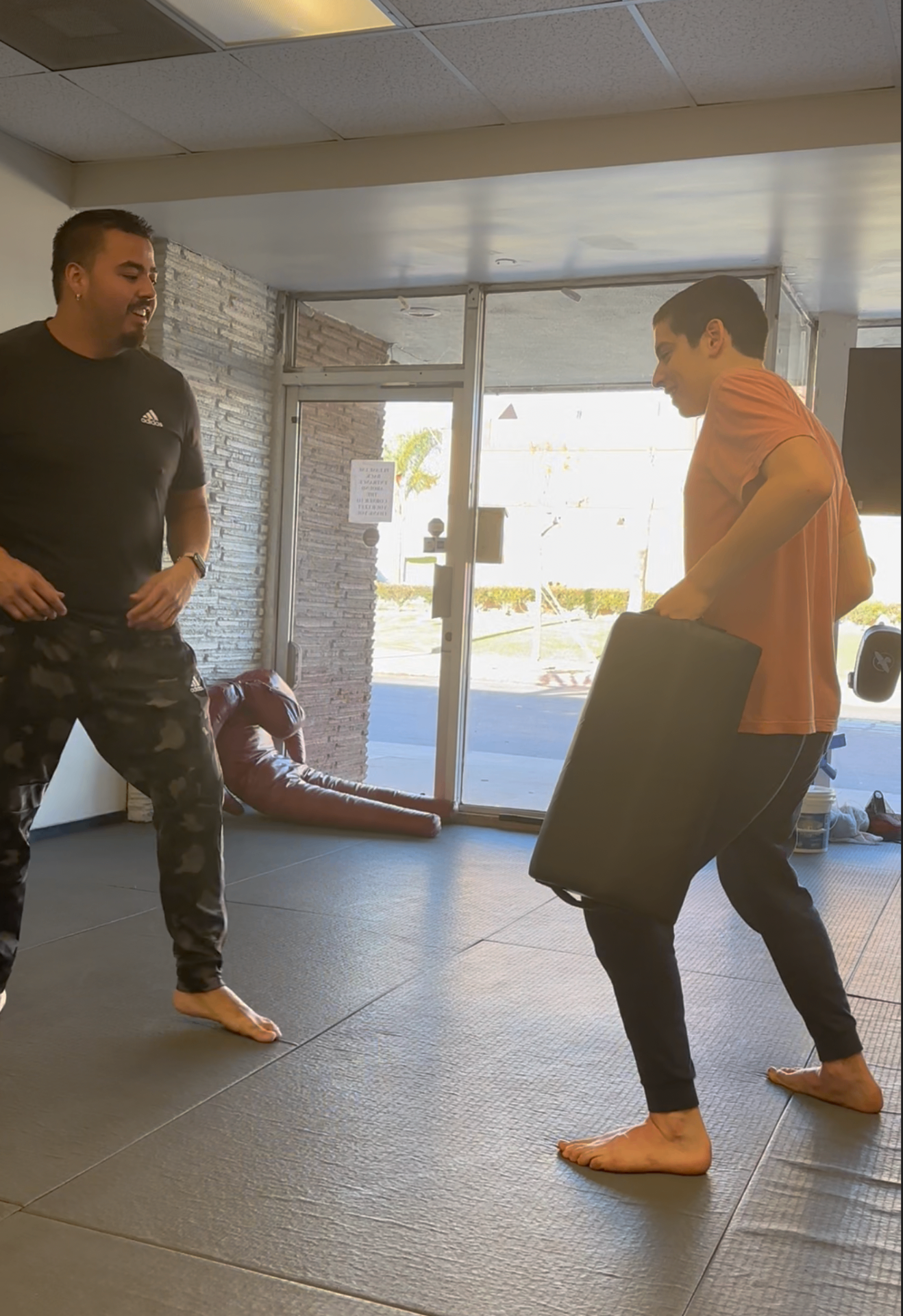 Clayton coaching a mentee through pad work